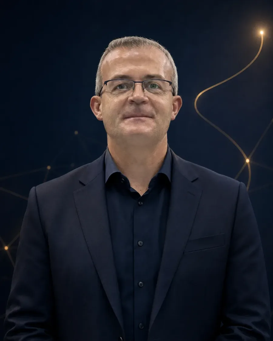 Porträt von Andreas Petri, Vertriebsleiter, vor tiefblauem Hintergrund mit feinen goldenen Lichtlinien